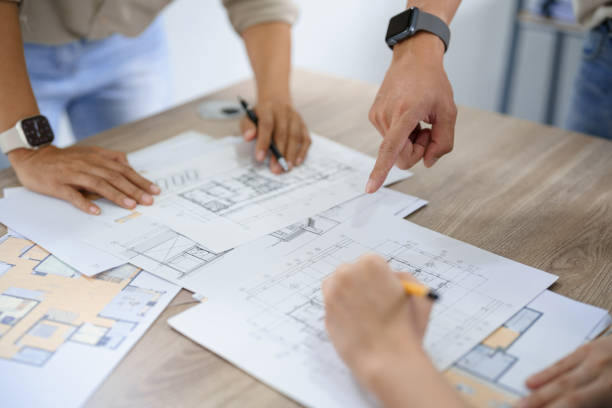 istock Engineering construction concept, Engineers team point blueprint of building to discussing together 1640285109