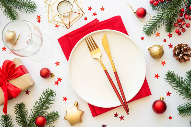 istock Christmas table setting with plate, cutlery and christmas decorations on white background. 1640286309