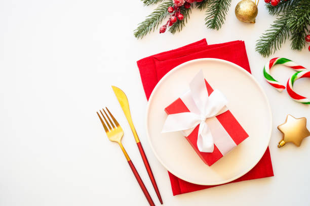 istock Christmas table setting with white plate and christmas decorations on white background. 1640286314