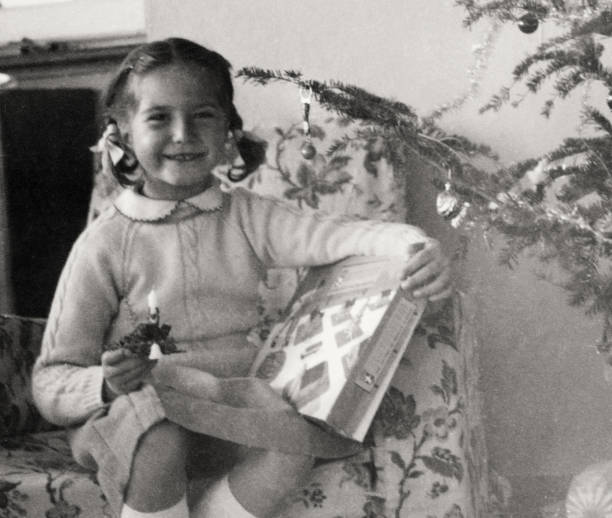 Little Girl sitting under Christmas Tree in 1954.