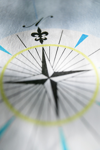 A compass rose on a map photographed with a very shallow depth of field.