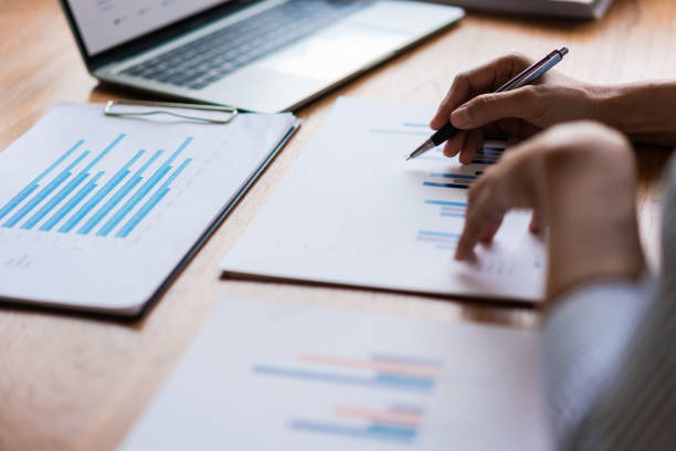 istock Close up hands of businessman is reading financial document and writing down notes in paperwork 1640312009