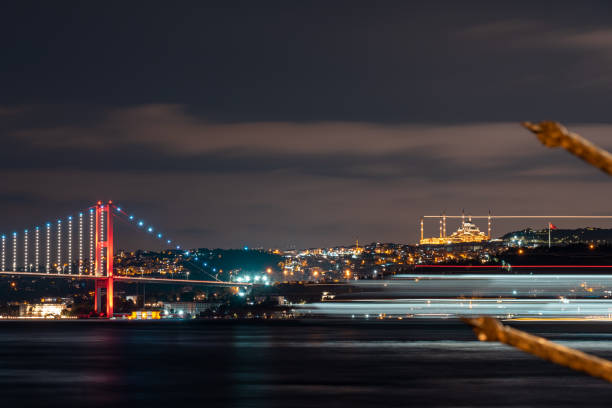 View of Camlica Mosque and Bosphorus Bridge. colored lines formed by the lights of the moving steamers. A beautiful night view of the Bosphorus. Istanbul Türkiye View of Camlica Mosque and Bosphorus Bridge. colored lines formed by the lights of the moving steamers. A beautiful night view of the Bosphorus. Istanbul Türkiye bogaz stock pictures, royalty-free photos & images