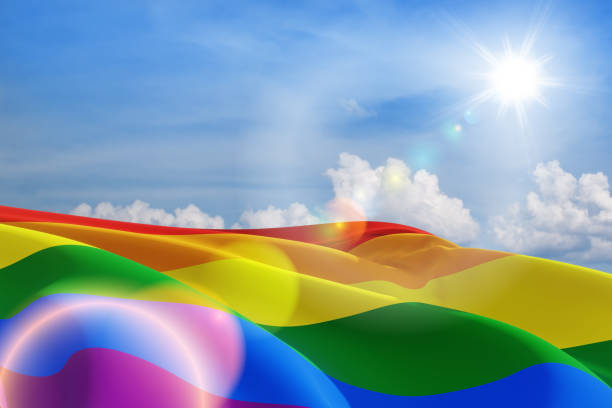 agitando bandeira do orgulho lgbt no céu azul, fundo da bandeira do arco-íris. movimento multicolorido da bandeira da paz. - sexual issues fotos - fotografias e filmes do acervo