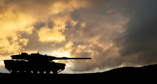 istock Silhouette of army tank at sunset sky background. 1640335104