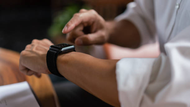 istock Hands of businessman checking time on smartwatch while working about financial document of business 1640337734