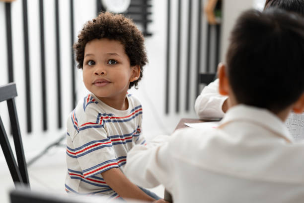 istock Happy African American kid boy studying with friend in classroom 1640338876