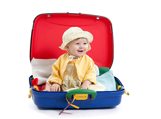 istock baby girl seated in a suitcase on white 164034482