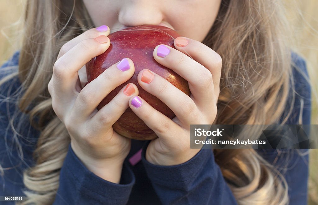 Niña comer refrigerio saludable de manzana - Foto de stock de 8-9 años libre de derechos