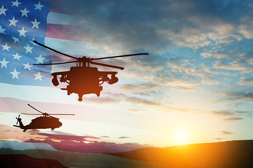 Silhouettes of helicopters on background of sunset with a transparent American flag. Greeting card for Veterans Day, Memorial Day, Air Force Day. USA celebration.