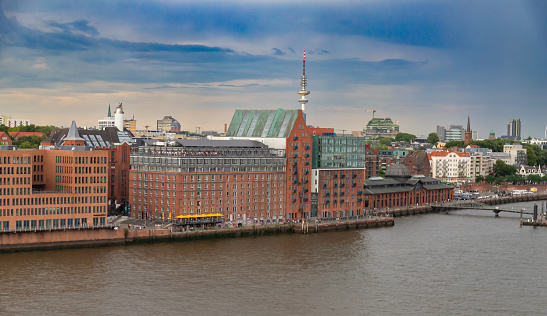 Hamburg, Germany - July 15, 2023: Elbe reservoir on the Elbe. Big building with hotel, restaurants and company offices. The restaurants are full of tourists.