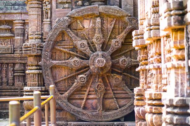 Antique sun wheel depicting chariot and sundial of sun emple at Konark odisha, India An antique sun wheel, depicting a chariot and sundial, sits in front of the Sun Temple in Konark, Odisha, India chariot wheel at konark sun temple india stock pictures, royalty-free photos & images
