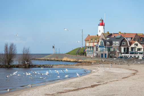 Seagulls flying by the lighthouse in Kolobrzeg, Poland.