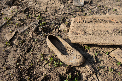 An old-fashioned plastic child's shoe in an abandoned village.