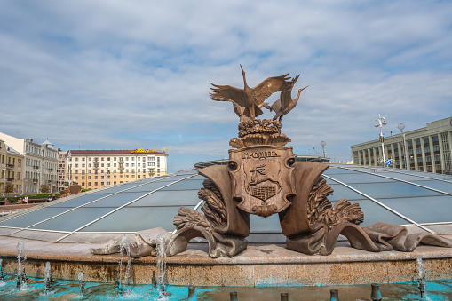 Minsk, Belarus - Jul 30, 2019: Fountain of Independence or Fountain of Three Storks with Hrodna (Grodno) Coat of Arms at Independence Square - Minsk, Belarus