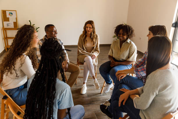 istock Group of young people sitting in a circle, talking about their problems during a group therapy session 1640540222