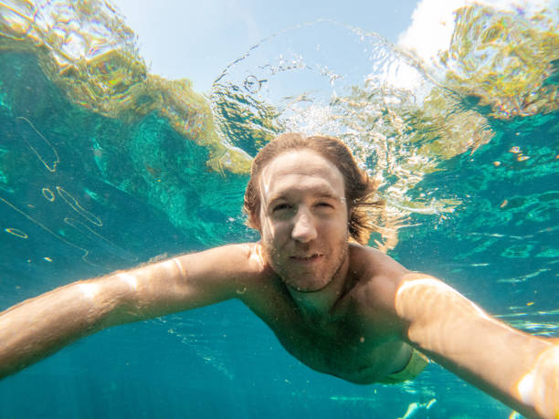 istock Man takes selfie underwater while swimming in a clear clean water 1640547284