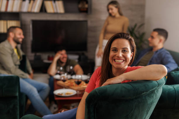 istock Charming young woman hanging out with friends, smiling at camera 1640570421