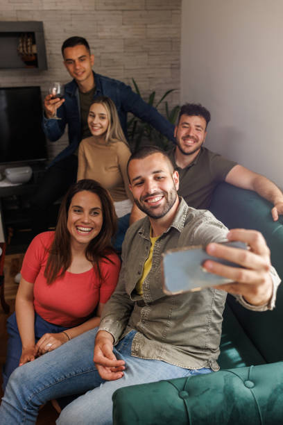 istock Cheerful group of friends taking selfies together 1640570426
