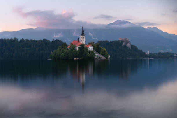 lago da montanha com uma pequena igreja no meio completamente isolada da água - santa maria church - fotografias e filmes do acervo