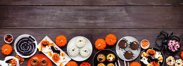 istock Spooky Halloween dessert bottom border over a dark wood banner background 1640586171