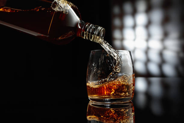 istock Pouring whiskey from a bottle into a glass. 1640590447