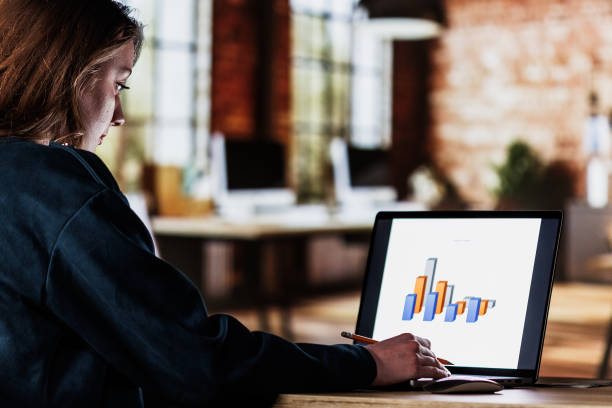 istock Young woman working on a project at her desk late at night 1640602278