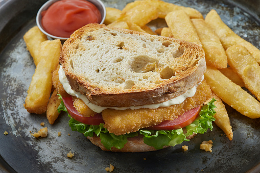 Fish Stick Sandwich with Ice Burg Lettuce, Tomato, Tarter Sauce and Steak Cut Fries on Toasted Sourdough Bread