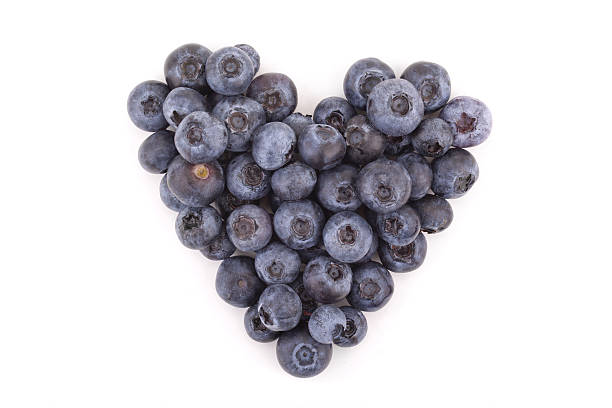 Small heart with blueberries on white background.