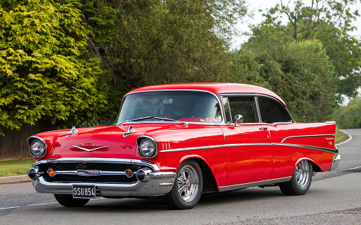 Whittlebury,Northants,UK -Aug 26th 2023: 1957 red Chevrolet Bel Air American car travelling on an English country road