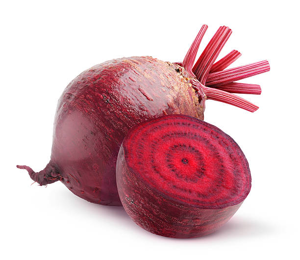 whole beetroot next to one cut in half on a white background - biet stockfoto's en -beelden
