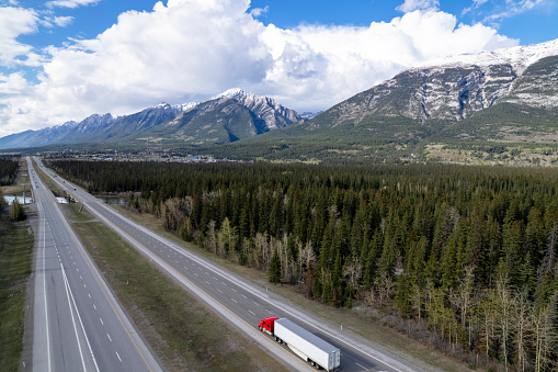 Transport truck travelling through the Rocky Mountains. Scenic photos of transport trucks on the open road.