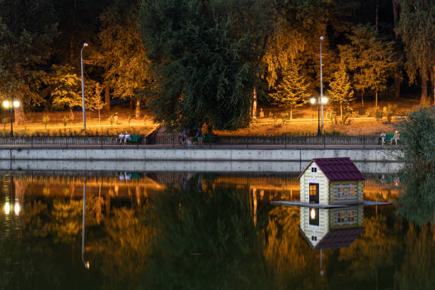 Warm orange lights reflected on a lake in a public park at night in Chisinau, Moldova