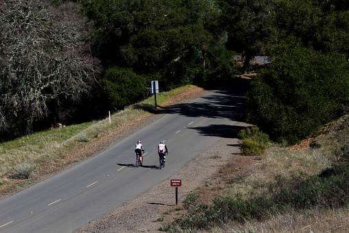 Man And Woman On Mountain Road Riding Bicycles At 2000 Feet Elevation
