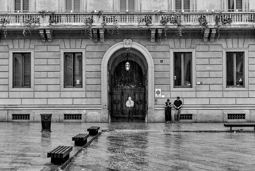 Milan, Italy - July 14, 2023: People staying out of the rain in the courtyard adjacent to the Museo del Cenacolo Vinciano in Milan, home of Leonard DaVinci's 