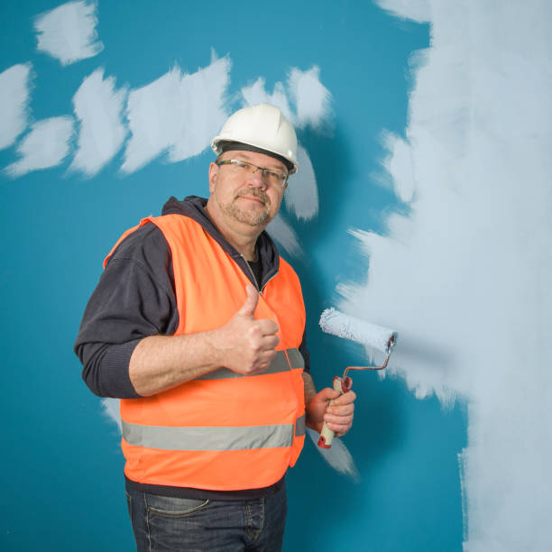 istock Painter applied a primary coat of paint. Ground coat of light paint on a dark wall. 1640836062