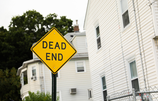 Dead End sign stands against a desolate backdrop, embodying finality, halted progress, and the need for redirection in life's journey