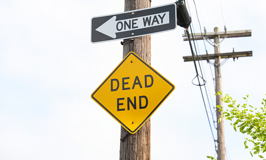 Dead End sign stands against a desolate backdrop, embodying finality, halted progress, and the need for redirection in life's journey