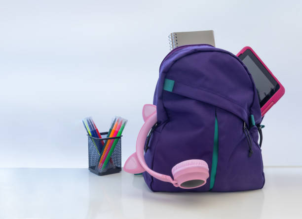 istock A student school bag pack with headphones, a notebook and a tablet on a white table with pens markers. 1640870573