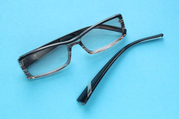 istock Old broken eyeglasses with damaged legs on blue background. Poor eyesight. Reuse and repair concept. Idea of health. Failure optic eyewear. Breakage of vision correction glasses. Close up, flat lay 1640899859