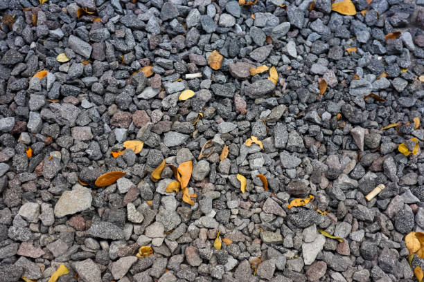 istock Small gravel stone with dry leaves as texture background 1640947416