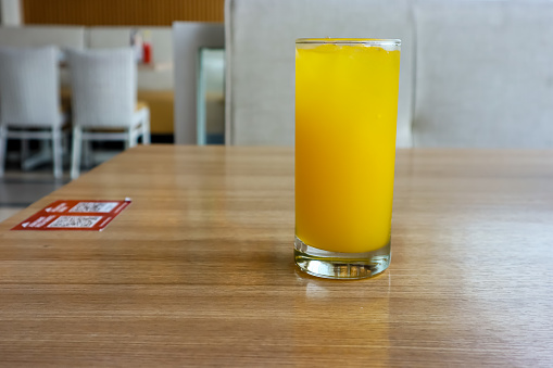 A glass of orange juice on the wooden table, look fresh as a summer drink. Copy space