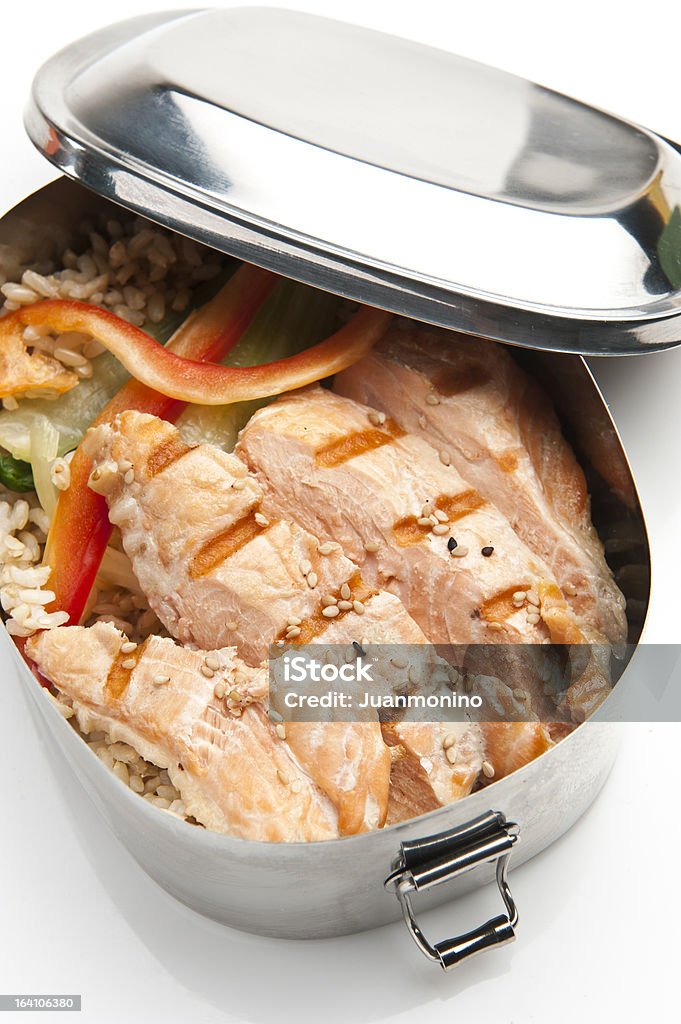 grilled salmon in a lunch box in a white background grilled salmon over fried rice in a lunch box on white background Lunch Box Stock Photo