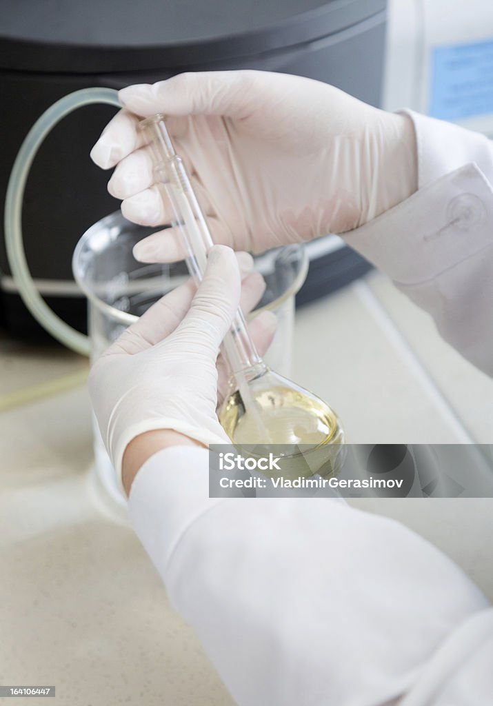 Manos sosteniendo un matraz en los análisis de laboratorio - Foto de stock de Agarrar libre de derechos