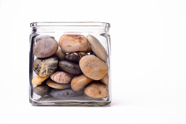 Jar of rocks A glass jar filled with smooth rounded stones. jar stock pictures, royalty-free photos & images