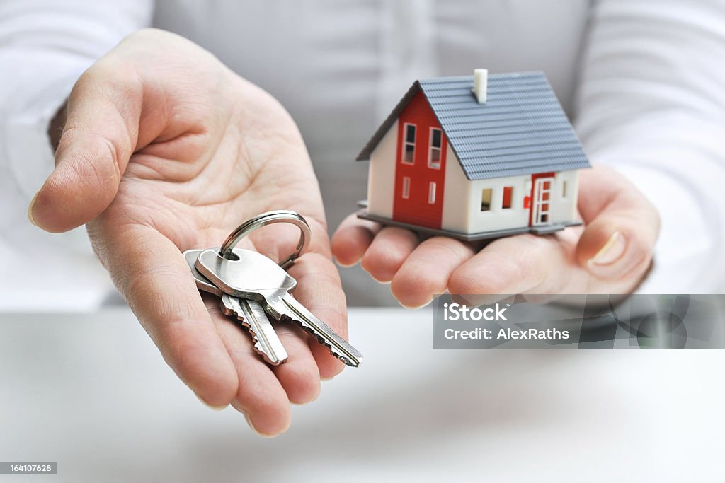 House and keys Real estate agent with house model and keys House Stock Photo