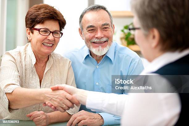 An Old Couple Shaking Hands With An Unseen Woman Stock Photo - Download Image Now - Financial Advisor, Senior Adult, Couple - Relationship