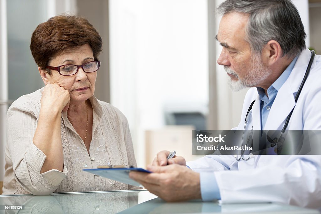 Male doctor explaining something to female patient Patient tells the doctor about her health complaints Patient Stock Photo