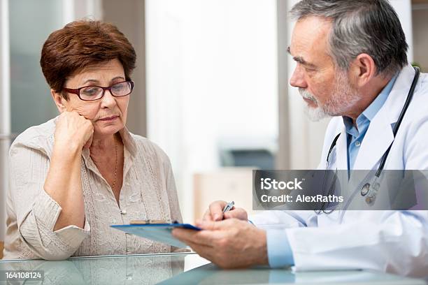 Male Doctor Explaining Something To Female Patient Stock Photo - Download Image Now - Patient, Doctor, Distraught