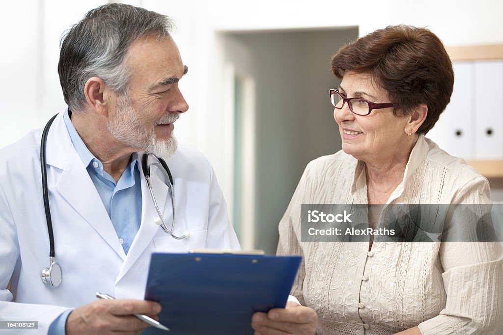 Medical exam Doctor discussing treatment with senior female patient Doctor Stock Photo